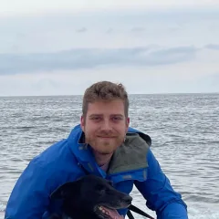 Bennet Gallein, Geschäftsführer, mit seinem Hund am Strand